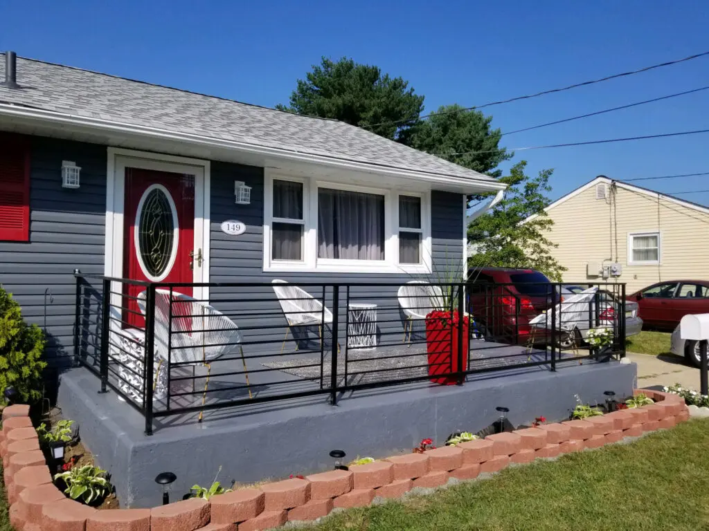 juniper-after House with new paint on the exterior railing added to their stained concrete patio done by A Women's Brush