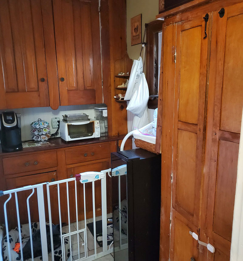 Cabinet pantry area cluttered before work begins